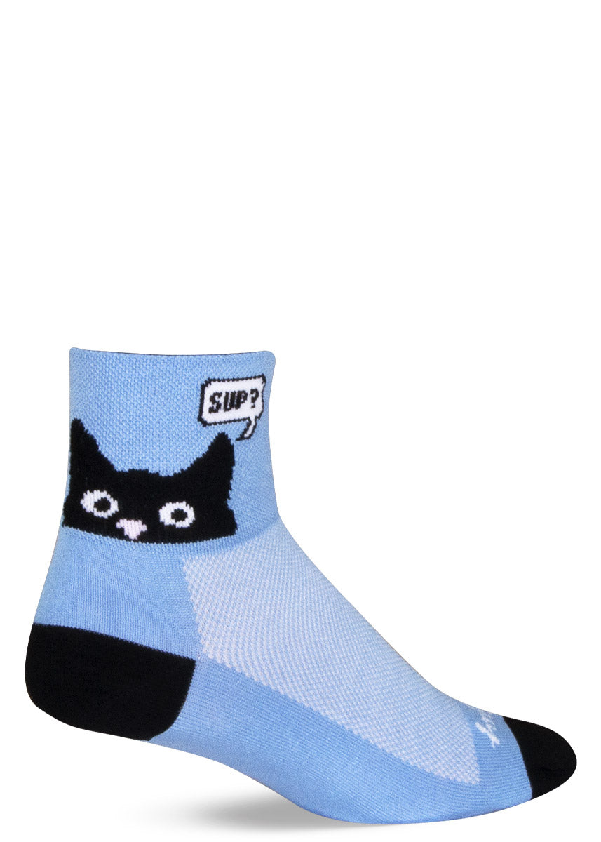 Light blue athletic ankle socks with a black cat face peeking up on the cuff with a speech bubble that says, "Sup?"