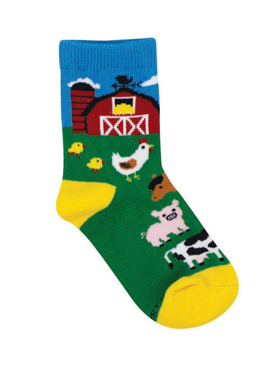 Blue and green crew socks for kids show a red barn and barnyard animals including a chicken and chicks, a horse, a pig, and a cow. 
